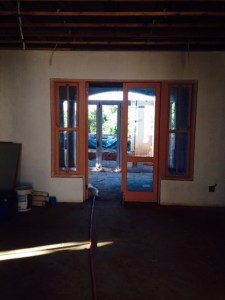Taken from library sliding door opening, looking north, through living area and patio to garden.