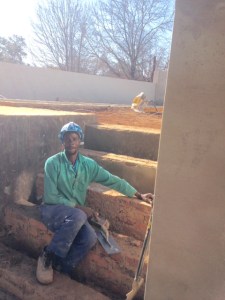 Godfrey, a bricklayer, working on the steps from the garden to the path.